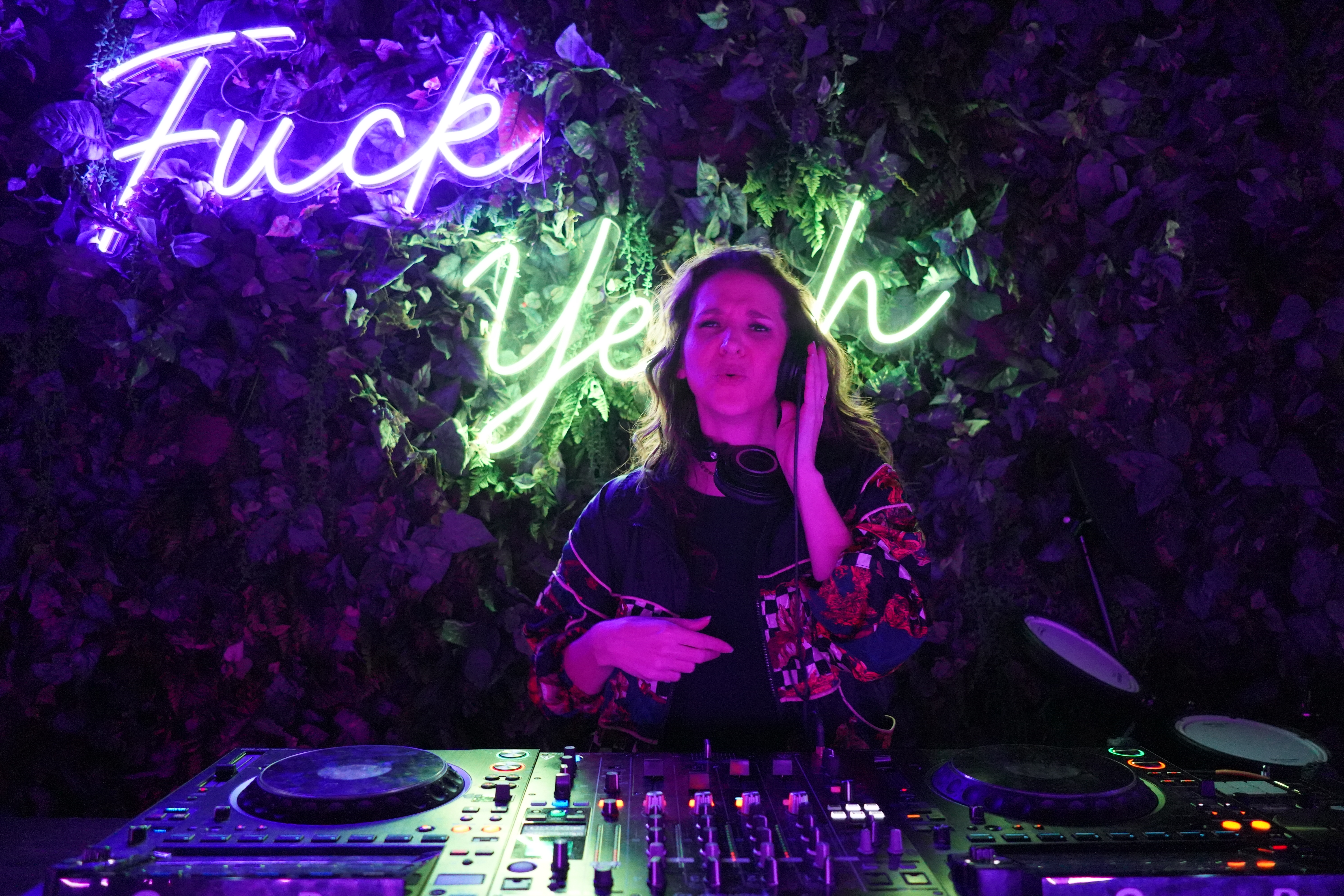 IZBO DJing under a neon sign at Beacon in Denver. She is an unsigned bass house DJ and vocalist.