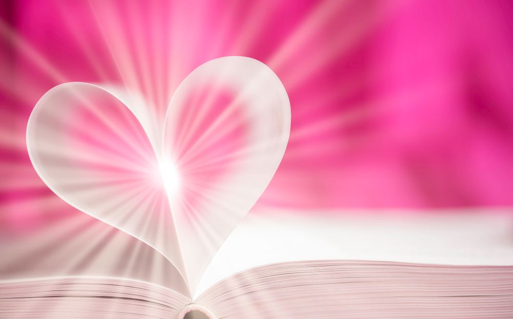 Pages d'un livre repliées en forme de coeur avec de la lumière au centre