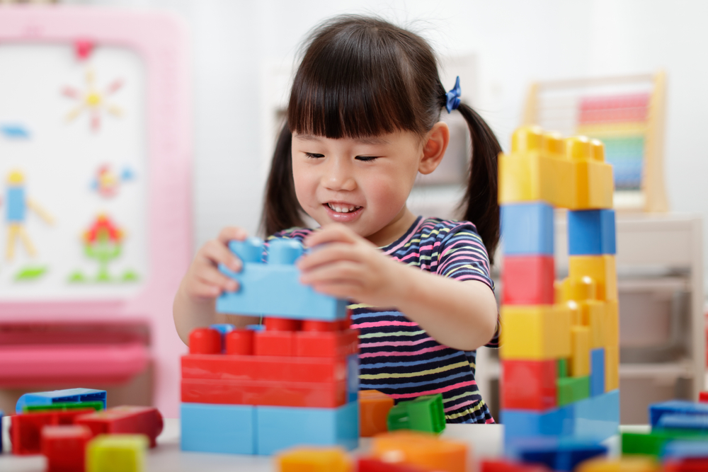 Petite fille qui joue avec des blocs de construction