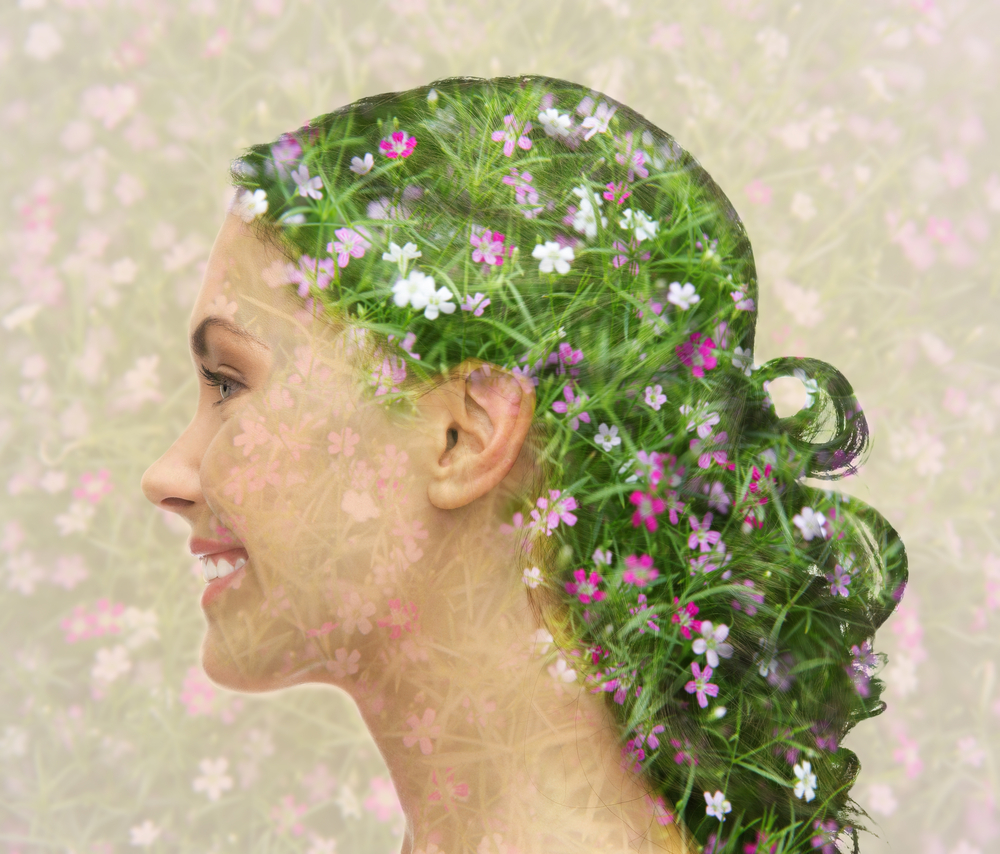 Profil de femme souriante avec des fleurs dans ses cheveux